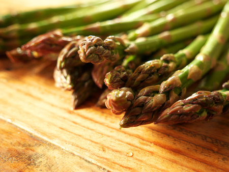 A closeup of ripe asparagus on a wooden table in the kitchenの写真素材