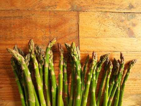 A top view of ripe asparagus on a wooden table in the kitchenの写真素材