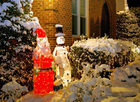 Outdoor Santa and Snowman decorations covered in snow                の写真素材