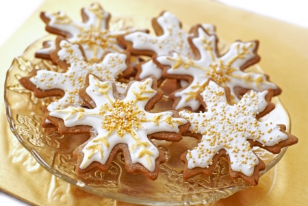 Snowflake gingerbread cookies decorated with icing, gold, and pearls.               の写真素材