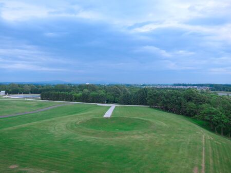 The view of a large circular grass field on a cloudy dayの写真素材