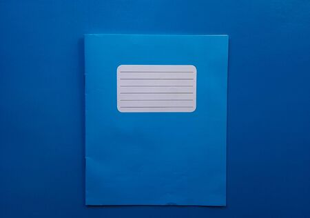 Old copybook on a blue background. School notebook, preparation for September 1 and the new school year.の写真素材