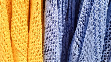 Colors of rainbow. Variety of casual shirts, t-shirts on hangers in a store. Cloth cotton of various bright colors close-up. Textile background.の写真素材