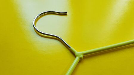 Hanger for clothes on a yellow background. Green hanger. Background with copy space. Black friday, shopping day.の写真素材