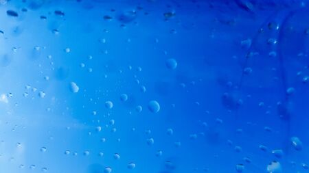 A lot of drops of water inside a plastic bottle. Blue background with water drops.
