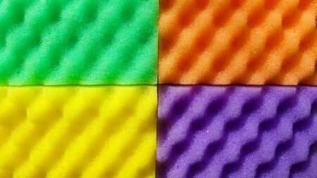 Multi-colored washcloths are laid out in rows on a bright background, close-up. place for text. Copy...