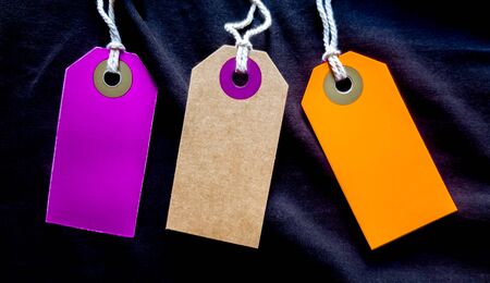 Three fashionable label mockups for clothes on a black background. Clothes sale.