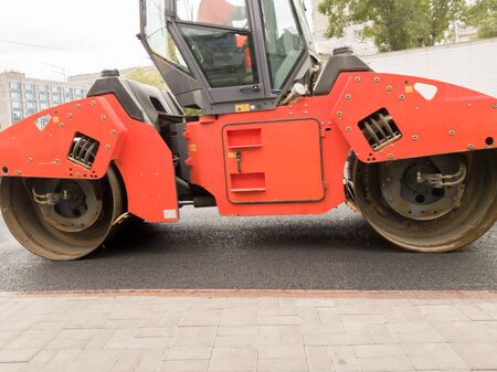 Road roller building the new asphalt road. Heavy asphalt roller that stack and press hot asphalt....