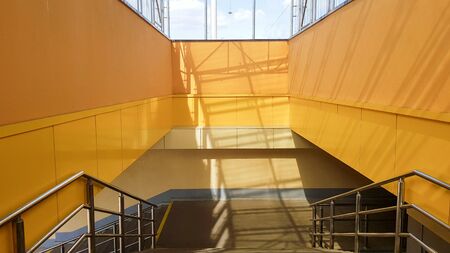 light rail station. Design of a bus stop and a pedestrian underpass with steps and railings made of yellow panels and a glass roofの写真素材