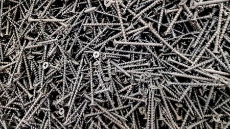 steel screws, metal screw, iron screw, screws as a background, wood screw. Iron or metal screw nails stack industrial building industry backgroundの写真素材