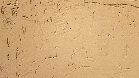 Old gold plaster wall texture yellow background. Textured textured wall plaster. Embossed wall decoration. Stucco walls. Embossed wall decoration. Decorative plaster is painted yellowの写真素材