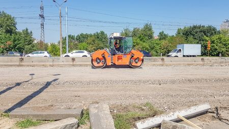 Ukraine, Kiev - October 1, 2019: Road roller, tractor and construction equipment are working on a...