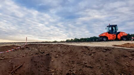 Ukraine, Kiev - October 1, 2019: Road roller, tractor and construction equipment are working on a...