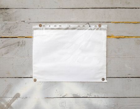 White paper sign with rivets, vintage background on a gray wooden old backdrop. Wooden textured...