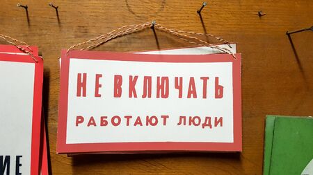 Tables at a factory or production with Russian text from the times of the USSR. Hazard warning text. Do not include people in the work, stop supplying voltage, work here, ground. Signs with text.の写真素材