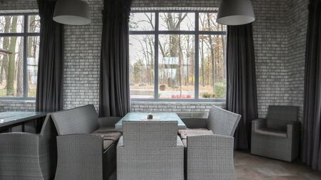 Ukraine, Kiev - October 22, 2019: rattan wicker furniture in a cafe interior with large windows and...
