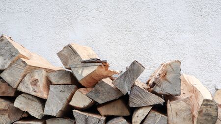 A neatly folded log of chopped wood. The fire is melting. Firewood stacked on top of each other. Firewood is collected for heating in cold weather. Background texture of stacked dry firewoods.の写真素材