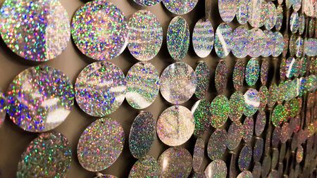 Macro close up of sparkles. Abstract background with gray sparkles. Texture scales of round spangles with color transition. Sequin background. Template for design. Festive background.の写真素材