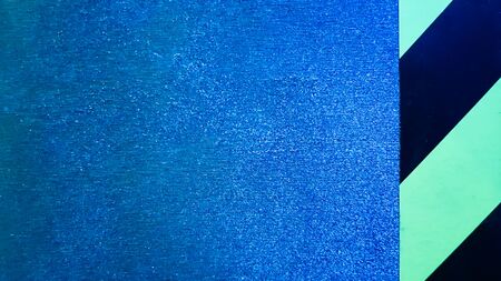 diagonal yellow and black stripes on a blue problem wall. Abstract colorful minimalist pattern....