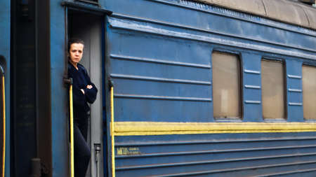 Ukraine, Yaremche - November 20, 2020: A train conductor, a woman of European appearance, in dark...
