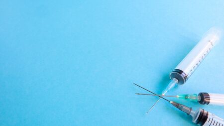 Three medical disposable plastic empty syringes with needles of different sizes and volumes. Vaccination concept, quarantine, self isolation, protection against coronavirus, medicine. copy space.の写真素材