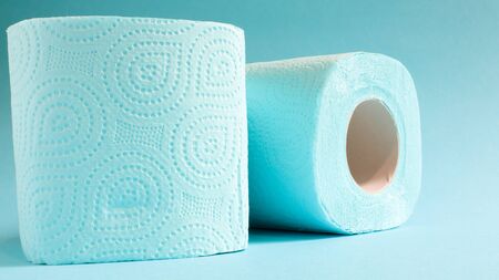 Blue roll of modern toilet paper on a blue background. A paper product on a cardboard sleeve, used for sanitary purposes from cellulose with cutouts for easy tearing. Embossed drawing.の写真素材
