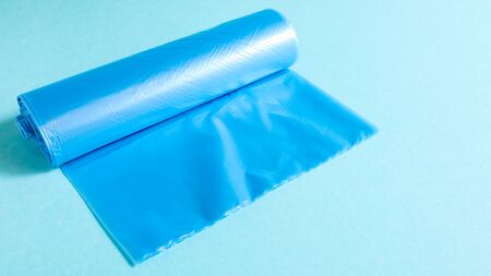 One roll of plastic garbage bags in blue on a blue background. Bags that are designed to accommodate garbage in them and used at home and placed in various garbage containersの写真素材