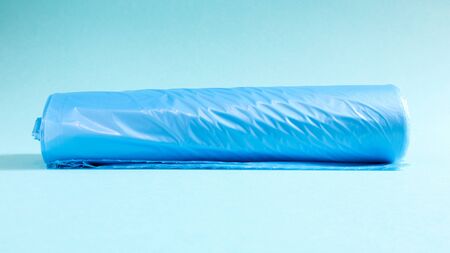 One roll of plastic garbage bags in blue on a blue background. Bags that are designed to accommodate garbage in them and used at home and placed in various garbage containersの写真素材