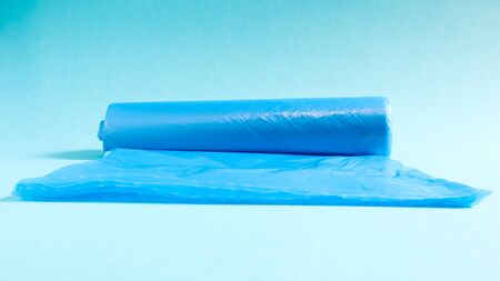 One roll of plastic garbage bags in blue on a blue background. Bags that are designed to accommodate garbage in them and used at home and placed in various garbage containersの写真素材