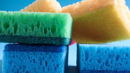Many blue, red, yellow, green sponges are used to wash and wipe the dirt used by housewives in everyday life. They are made of porous material such as foam. good detergent retention.の写真素材