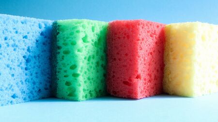 Many blue, red, yellow, green sponges are used to wash and wipe the dirt used by housewives in everyday life. They are made of porous material such as foam. good detergent retention.の写真素材