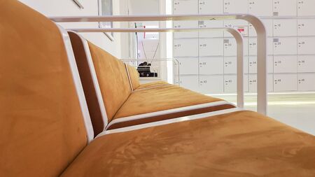 close-ups of benches upholstered in brown suede or leather with white metal railing in a cinema waiting room in a shopping center.の写真素材