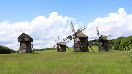 Ukraine, Kiev - June 11, 2020. Old Ukrainian wooden windmills of the XIX century. Summer outdoor landscape. Open-air museum of folk architecture and life, Pirogovo, Ukraine. Tourism and travelのeditorial素材