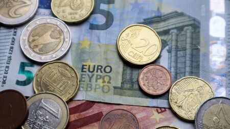 A few metal coins and paper notes of the European Union. Euro cash closeup