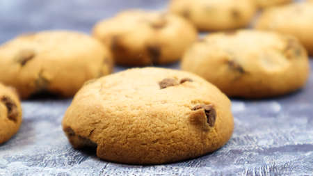 Soft, freshly baked chocolate chip cookies on a gray marble kitchen countertop. American traditional...