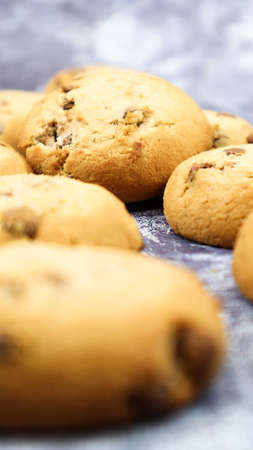 Soft, freshly baked chocolate chip cookies on a gray marble kitchen countertop. American traditional sweet pastry pastry, delicious homemade dessert. Culinary background. Selective focus.の写真素材