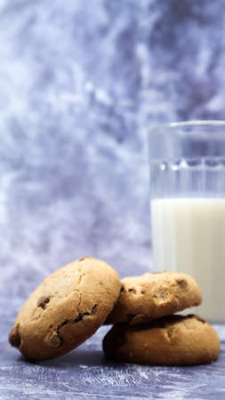 American gluten free chocolate chip cookies with glass glass of vegetable milk on gray background....