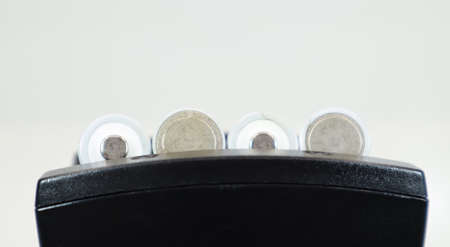 Fast charging of AA batteries. Rechargeable batteries in a black charger with four battery cells on a white backgroundの写真素材