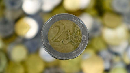 A close-up shows one 2 euro coin. This is money. Finance currency symbol. Blurred money background....