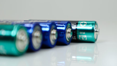 AA alkaline rechargeable batteries on white glossy background with reflection with copy spaceの写真素材