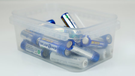 Clear plastic box full of used household AA alkaline and lithium-ion batteries collected for recycling in special waste bins. Recycling and ecology problems. Ukraine, Kiev - January 7, 2021のeditorial素材