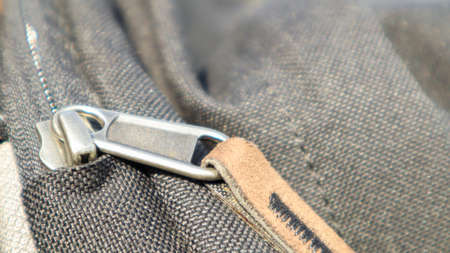 Zipper black bag backpack textile accessories. Close-up view of the clasp. Textile, metal and brown...