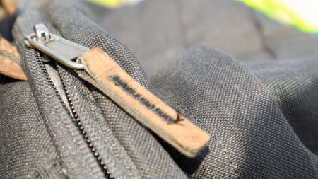 Zipper black bag backpack textile accessories. Close-up view of the clasp. Textile, metal and brown...
