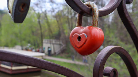 Red padlock metal love heart shaped lock on the bridge. The concept of love. Valentine's day backgroundの写真素材