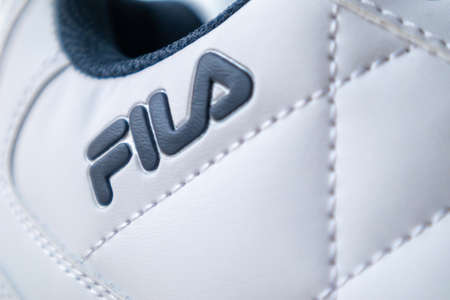 Fila footwear sign. One of the world's largest sportswear companies. New beautiful white sneakers with Fila logo. The concept of sports and casual shoes. Ukraine, Kiev - June 18, 2021のeditorial素材