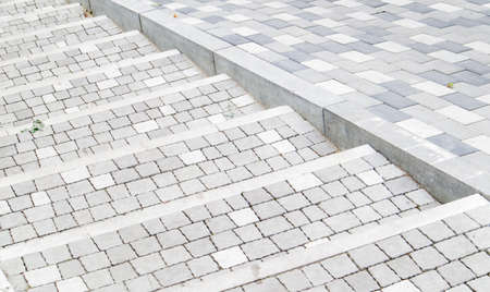 Steps from paving slabs and curbs. Rows of gray steps made of gray paving slabs are laid out evenly, consistently and tightly to each other. Paving stone steps slab gray backgroundの写真素材