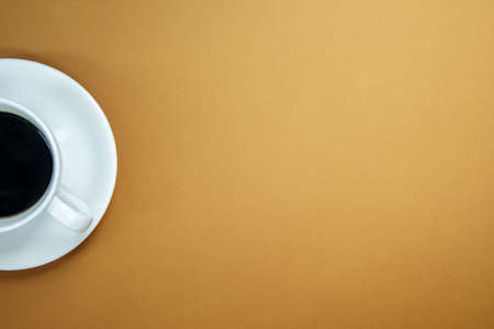 Black coffee in a white coffee cup on a gentle background. Top view, flat lay, copy space. Cafe and...