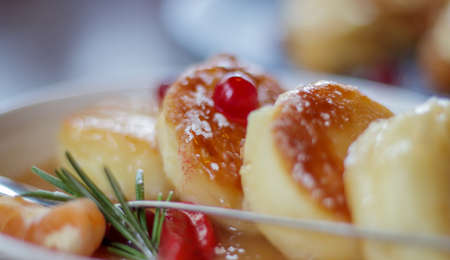 Close up fresh serving of four round paneer cheesecakes in salted caramel on a plate on the restaurant table in eco style. Cheesecakes or cottage cheese pancakes in a ceramic bowl. morning breakfastの写真素材