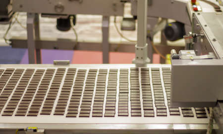 Line for the production of chocolate in an industrial factory. Automatic process in the production line of sweets. Images from the chocolate factory during production. Conveyor belt with sweetsの写真素材