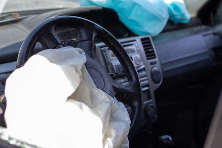 The driver's airbag deployed on the steering wheel of the car after the collision. Deflated airbags...